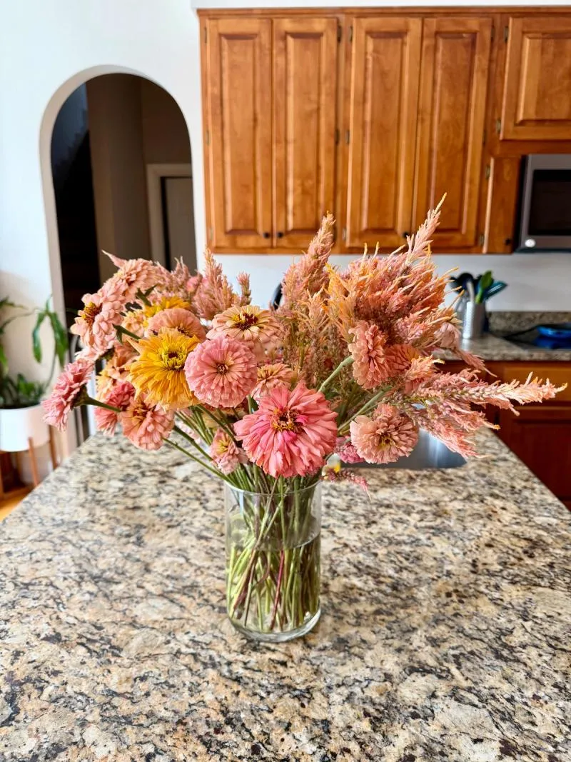 peach and warm yellows and orange zinnias and celosia on counter